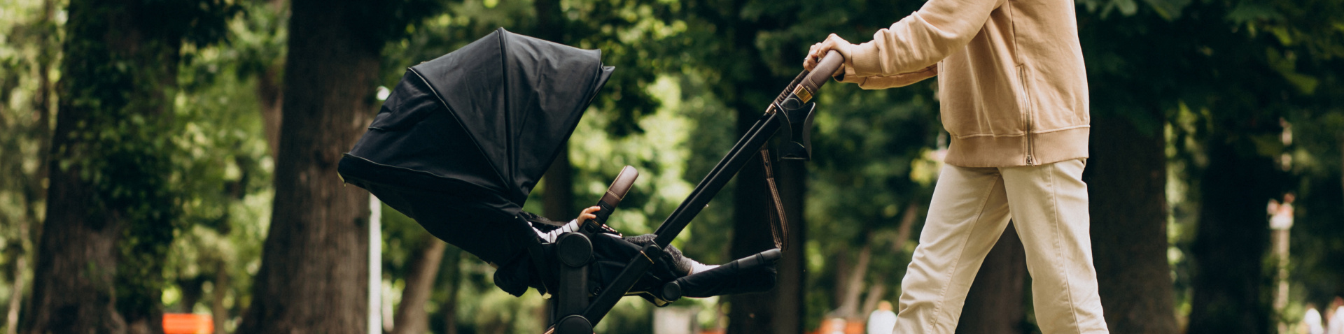 young-mother-walking-with-baby-carriage-park